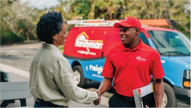 Mr. Handyman shaking hands with customer.